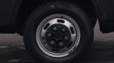 Close-up of a car wheel: steel rim with seven lug nuts and a Bridgestone tire to the side, resting on a dark surface.