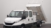 White Iveco dump truck with the cargo bed raised for unloading.