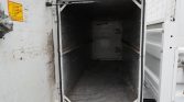 Open cold-storage trailer interior, empty and worn metal walls and floor, awaiting loading