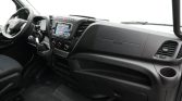Front cabin view of a vehicle interior showing the steering wheel, dashboard with infotainment screen, and gear selector from the driver's seat.