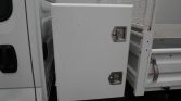 White metal utility storage box mounted on the side of a truck, with two latch handles.
