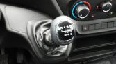 Manual gear shift lever with 6-speed pattern in a car interior, showing R, 1–6 and H-pattern.