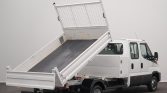 White utility truck with a raised dumping bed, ready to unload material in a studio setting.