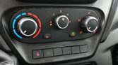 Dashboard climate controls: left temperature dial (blue/red), center fan speed dial, right airflow/direction dial; A/C on.
