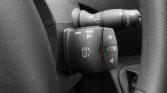Close-up of a car steering wheel stalk with media, radio, and phone controls on black plastic buttons