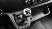 Six‑speed manual gear shift with the pattern R‑1‑3‑5 top row and 2‑4‑6 bottom row, set in a car’s center console with climate controls above.