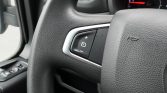 Steering wheel with cruise control buttons (+ and -) on the left side of the wheel to adjust speed.