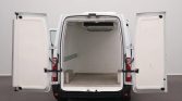 White cargo van with rear doors wide open, showing an empty cargo area and rear wheel wells on either side outside the van.