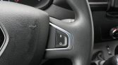 Close-up of a car steering wheel with a small switch showing letters 'R' and 'O' on a silver trim panel nearby.