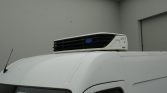 White van with a rooftop Carrier refrigeration unit installed.