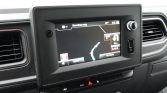 In-car navigation screen showing a map with a right turn ahead on a dark dashboard surface.