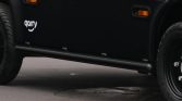Side view of a black vehicle with a white 'garry' logo on the door and orange marker lights.