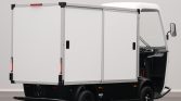 Small white delivery truck with a three-compartment box cargo area, rear doors closed, shown from a side-rear angle