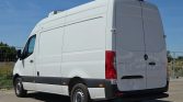 Rear and left-side view of a white Mercedes-Benz Sprinter cargo van with a high roof, parked on a sunny day.