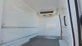 Empty refrigerated cargo trailer with ceiling cooling unit and metal checker-floor, ready for loading