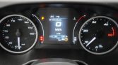 Car dashboard with center display showing 0 km/h, fuel warning icon lit, and left speedometer plus right tachometer visible, indicating the car is stationary to drive.