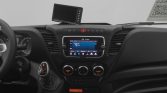 Interior of a car showing a central touchscreen infotainment system, climate controls, and a gear shifter with a small display mounted on the dashboard.