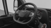 Interior of a vehicle cab showing a steering wheel with IVECO branding, instrument cluster, and gear selector in view.