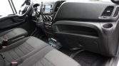 Interior of a vehicle cabin showing the front seats, steering wheel, and center console with a touchscreen display and climate controls.