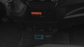 In-vehicle center console: gear shift on the left, orange dashboard display, and a blue TouchLog diagnostic device mounted below the controls.