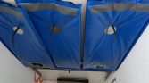 Three large blue insulated ceiling panels covering equipment in a utility room, with an orange cord along the wall