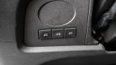 Close-up of a car dashboard with three small black buttons, each showing a white truck icon (likely trailer/auxiliary controls).