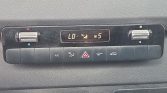Dual‑zone car climate panel with left/right dials, digital display reads LO and 5, plus A/C, hazard, defrost, and recirculation buttons.
