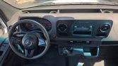 Mercedes Sprinter van cockpit: steering wheel, dashboard, and center console with radio display visible.