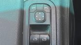 Power window controls with a four-way mirror adjustment pad on a car door panel.