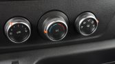 Car climate control cluster: three dials for fan speed, temperature, and airflow direction in a vehicle interior.