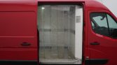Red cargo van with its side door open, exposing a metal storage area and partitioned interior.