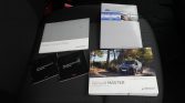 Renault vehicle manuals on a dark car-seat, including Radio Connect R&Go booklet, two black 70mai Dash Cam user manuals, and a Renault MASTER brochure with a van.