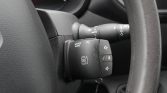 Close-up of a car steering wheel with a multifunction stalk: audio/source, telephone, and volume controls on the right side of the wheel.