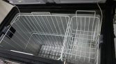 Open chest freezer with two white wire baskets and frosty, empty interior; power cord visible on the side.