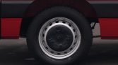Close-up of a car wheel with a black tire and silver hubcap on a red vehicle.