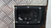 Close-up of a black control panel with power, settings, and up/down arrow buttons mounted on a diamond-plate metal surface (rugged, worn).","Worn industrial control keypad: power button, settings symbol, and up/down arrows, inset in metal plate.","Control panel on metal diamond plate with power, settings, and triangle up/down buttons visible.",