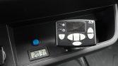 Car dashboard climate controller with a digital readout showing 20.3°C and a blue push button nearby.