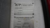 Two metal certification plates mounted on a white textured surface; the top plate reads ATP and 'Approved for transport of perishable foodstuffs' with fields for numbers and date, while the bottom plate lists the Coldtrans Serviss SIA model and serial number details and date as an identification tag for the unit.