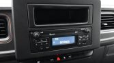 Car stereo in a dashboard displaying FM1 SKYRADIO on the blue screen