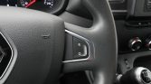 Close-up of a car steering wheel with a small control panel showing R and O, and a manual gear lever in the background.