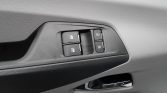 Close-up of a car door panel showing power window switches and door lock buttons on the armrest area.