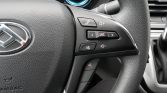 Close-up of a car steering wheel with audio controls: phone, volume, SRC, mute, and voice command button