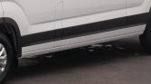 Side view of a white van showing its black lower trim and a wheel on the left.