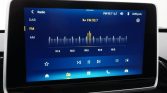 Car infotainment touchscreen showing FM radio interface tuned to 93.7, with a blue display and a frequency scale from 91.5 to 95.5; left menu shows DAB, FM, AM options, and playback icons along the bottom.