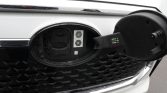 White car front with the circular fuel filler door open on the grille; inside are two hex-shaped labels reading 'C' and 'K'.