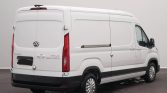 White cargo van photographed from the rear and side, with black bumper and closed rear doors, likely a delivery vehicle.