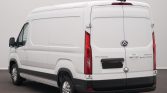 Rear and left-side view of a white cargo van with black bumper, showing rear doors and taillights in a studio setting
