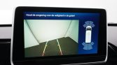 In-car display showing rear camera view with parking guideline lines (green, yellow, red) and a sensor radar around the car on the right.