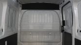 Empty white cargo van interior with open side and rear panels, showing blank metal walls and floor ready for cargo.