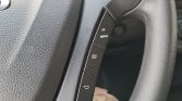 Steering wheel control panel with four vertical black buttons labeled OK, MENU, a print icon, and a return arrow (car interior).